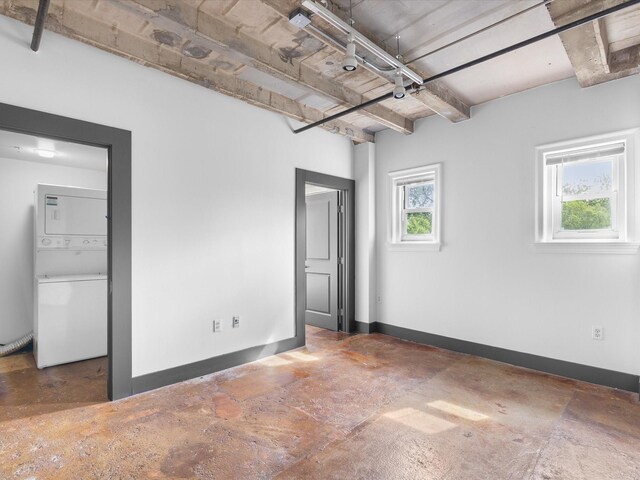 329 E Colorado Blvd Unit 202, Dallas, TX 75203 - unfurnished bedroom with baseboards, stacked washer and clothes dryer, concrete flooring, and beamed ceiling