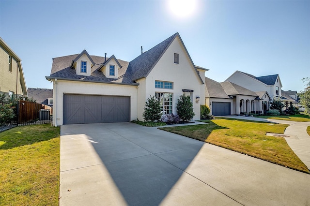 french country inspired facade featuring a front yard, a garage, and central AC unit