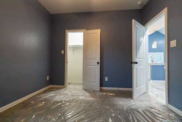 unfurnished bedroom featuring a spacious closet and a closet