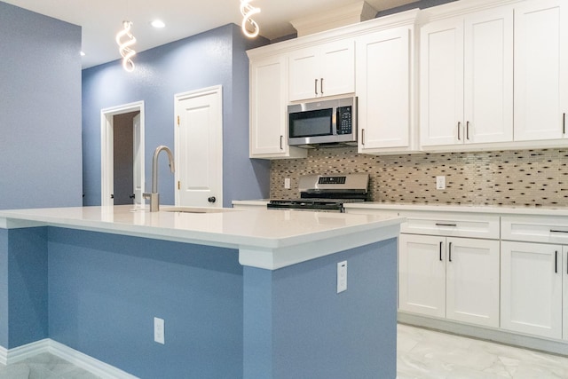 kitchen featuring appliances with stainless steel finishes, a center island with sink, white cabinets, and decorative backsplash