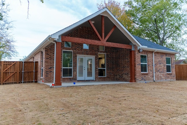 rear view of house featuring a patio area, french doors, and a lawn