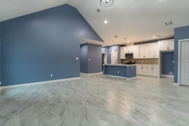 interior details featuring white cabinetry, range, and tasteful backsplash