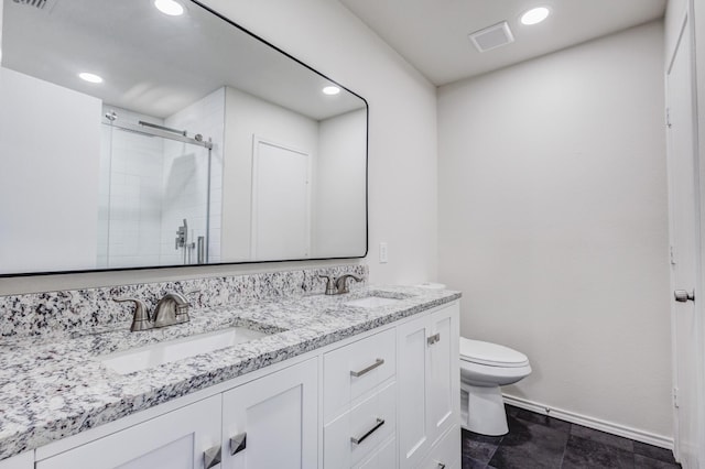 bathroom featuring vanity, toilet, and a shower with shower door