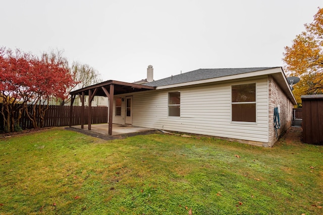 back of house with a patio area and a yard