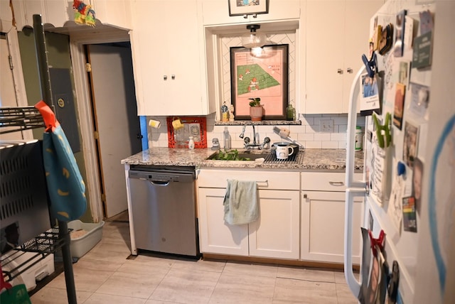 kitchen featuring white cabinets, stainless steel dishwasher, light stone countertops, tasteful backsplash, and white fridge