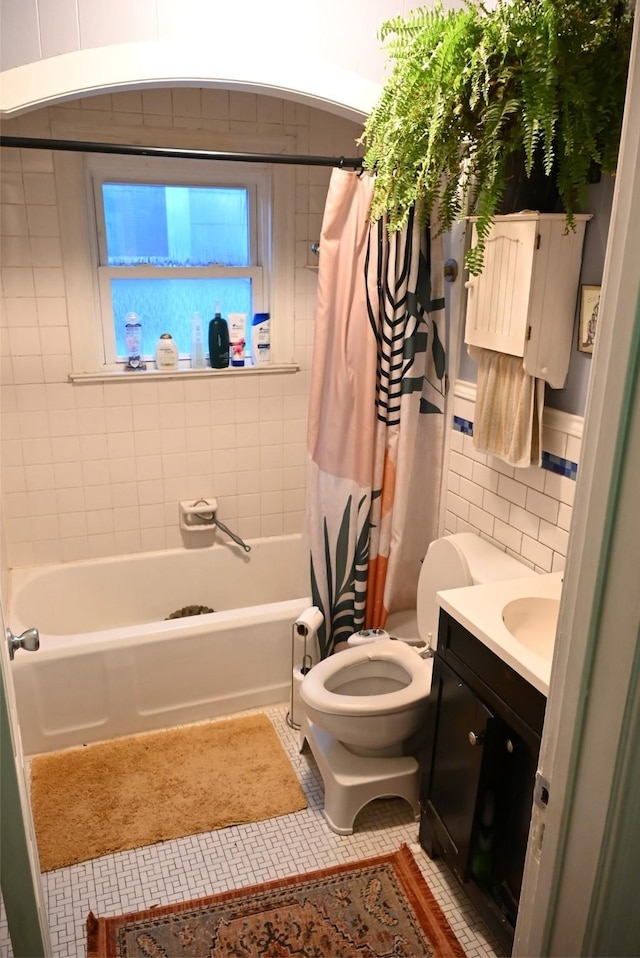 full bathroom featuring vanity, tile patterned flooring, toilet, shower / bathtub combination with curtain, and tile walls