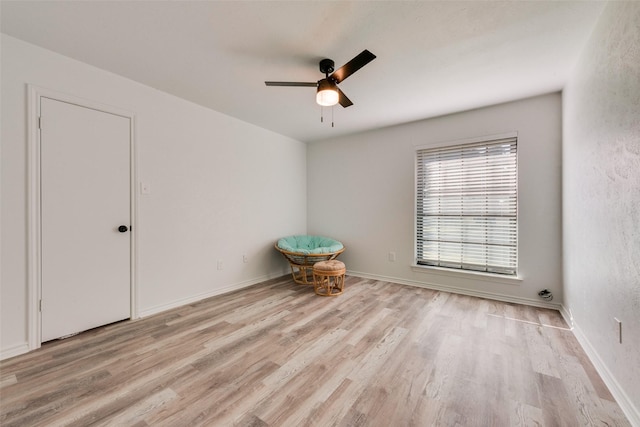 empty room with ceiling fan and light wood-type flooring