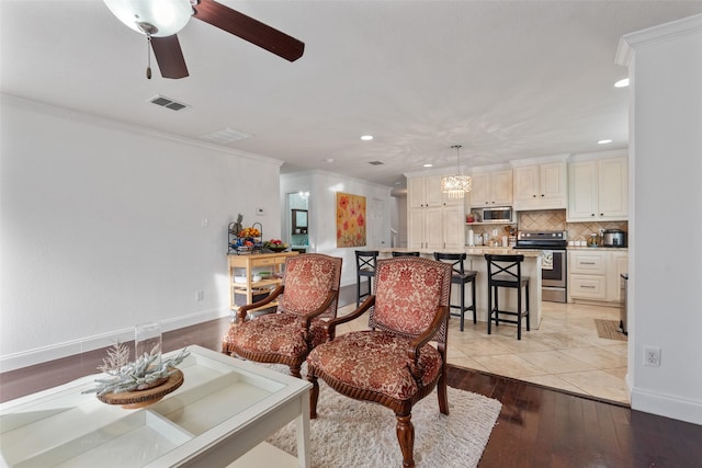 interior space featuring ornamental molding, ceiling fan, and light wood-type flooring