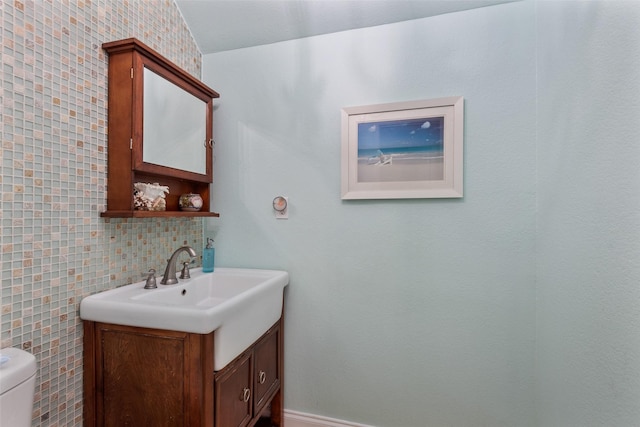 bathroom with vanity, tile walls, and toilet