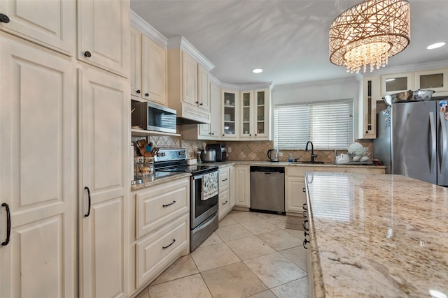 kitchen featuring sink, crown molding, light stone counters, decorative light fixtures, and appliances with stainless steel finishes