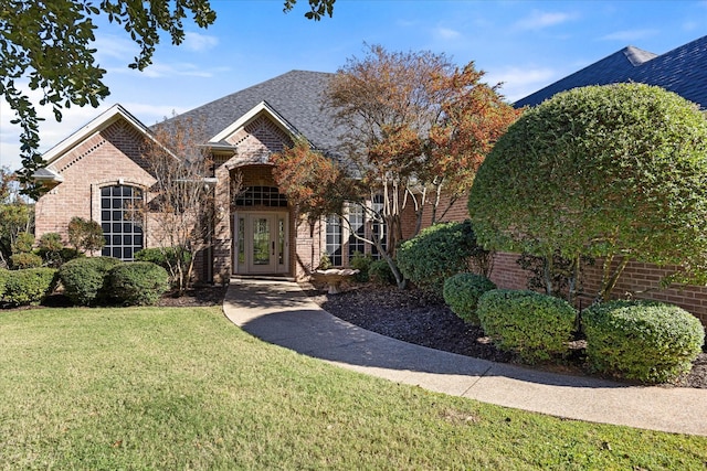 view of front of home with french doors and a front lawn