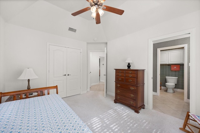 bedroom with connected bathroom, ceiling fan, vaulted ceiling, a closet, and light tile patterned floors