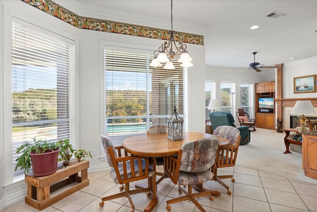 tiled dining space featuring ceiling fan with notable chandelier and ornamental molding