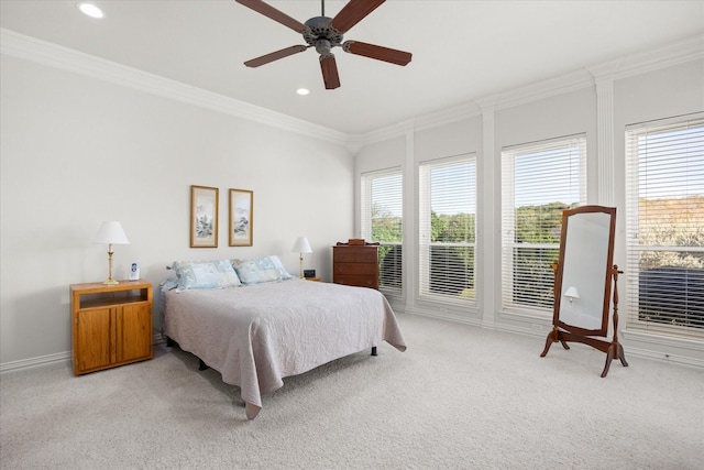 bedroom with multiple windows, ceiling fan, and light carpet