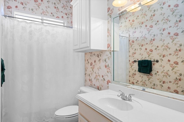 bathroom featuring vanity, curtained shower, and toilet