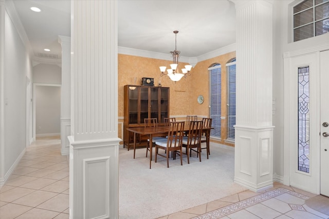 tiled dining room featuring a chandelier, crown molding, and decorative columns