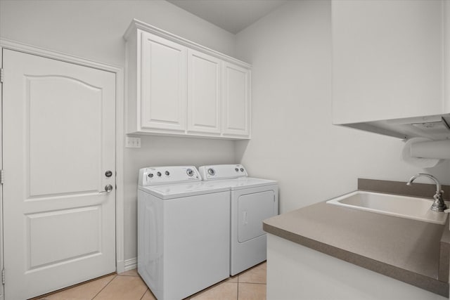 washroom featuring washer and clothes dryer, light tile patterned flooring, cabinets, and sink