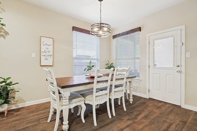 dining room with dark hardwood / wood-style floors and a chandelier