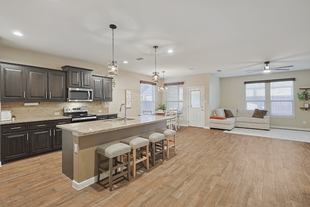 kitchen featuring a healthy amount of sunlight, a kitchen island with sink, sink, and stainless steel appliances