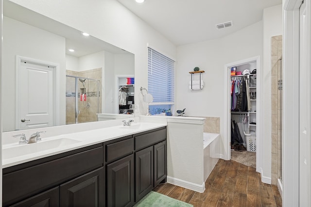 bathroom featuring hardwood / wood-style floors, vanity, and separate shower and tub