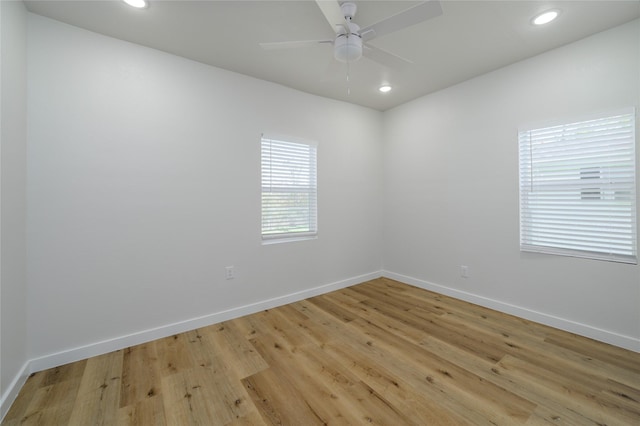 empty room with ceiling fan and light hardwood / wood-style floors