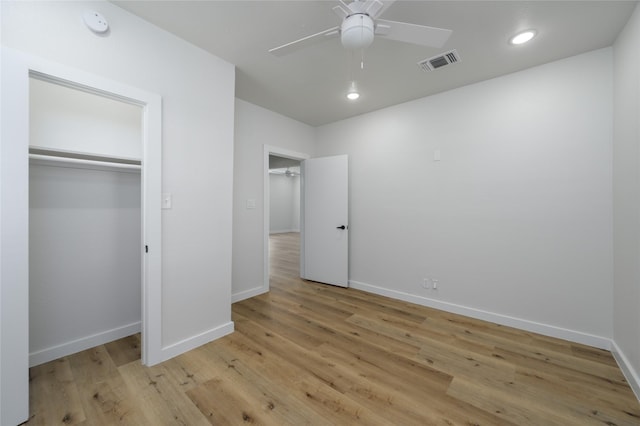 unfurnished bedroom featuring a closet, light hardwood / wood-style flooring, and ceiling fan