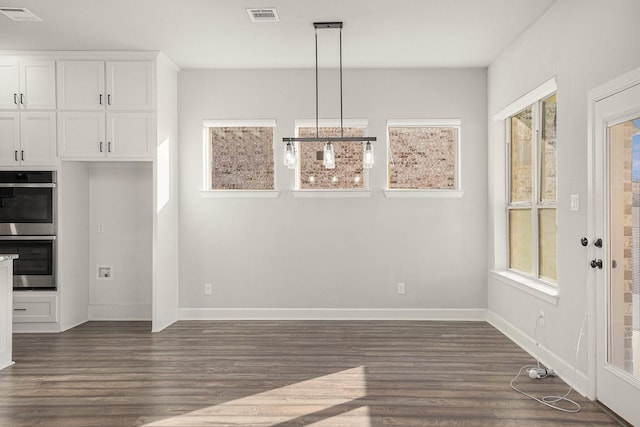 unfurnished dining area with dark hardwood / wood-style flooring