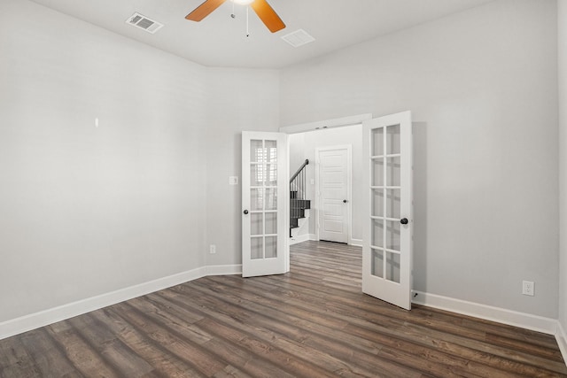 empty room with ceiling fan, dark hardwood / wood-style flooring, and french doors