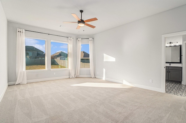 unfurnished room with light colored carpet and ceiling fan