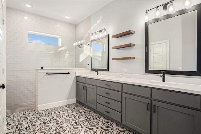 bathroom featuring vanity, a tile shower, and tile patterned floors