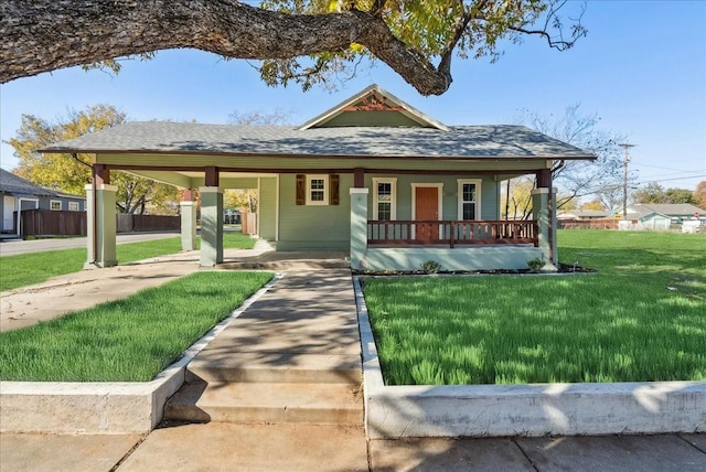 bungalow-style house with covered porch and a front lawn