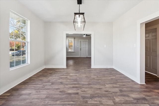 unfurnished dining area with dark wood-type flooring