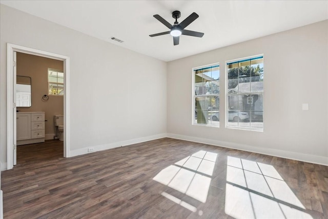 empty room with ceiling fan and dark hardwood / wood-style flooring