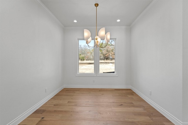 unfurnished dining area featuring a notable chandelier, crown molding, and light hardwood / wood-style flooring