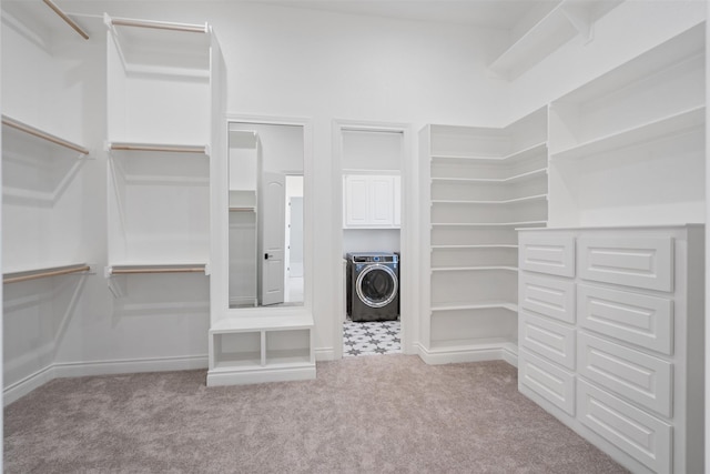 walk in closet featuring washer / clothes dryer and light carpet