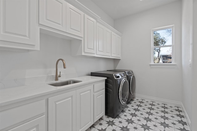 washroom with cabinets, separate washer and dryer, and sink