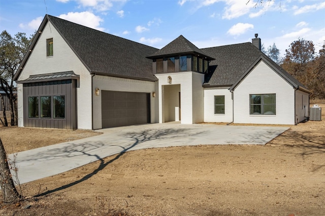 view of front of home with a garage and cooling unit