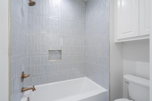 bathroom with tiled shower / bath combo and toilet