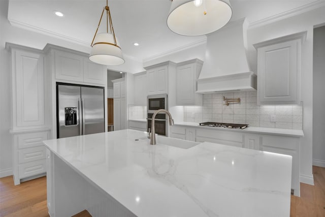 kitchen with premium range hood, sink, pendant lighting, stainless steel appliances, and light stone countertops