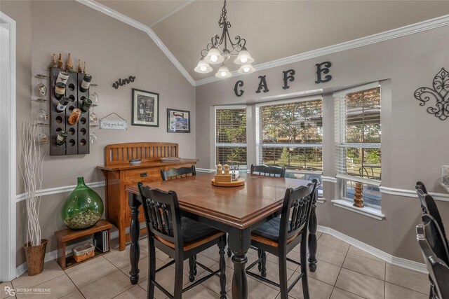 tiled dining area with a chandelier, ornamental molding, and lofted ceiling