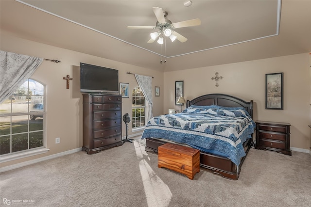 carpeted bedroom with ceiling fan and multiple windows