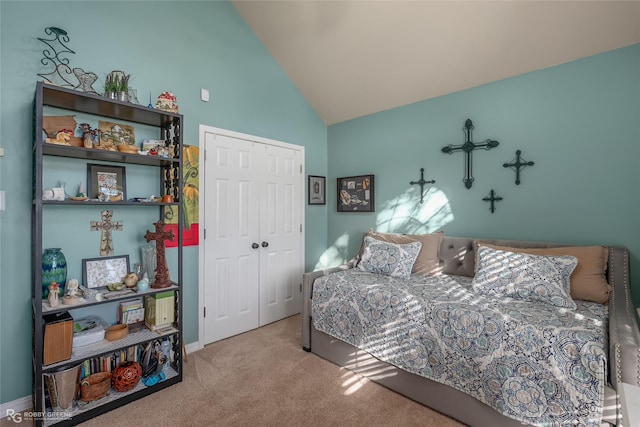 bedroom with lofted ceiling, light carpet, and a closet