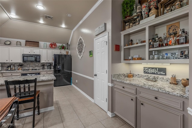 kitchen featuring black appliances, white cabinetry, light stone countertops, and crown molding