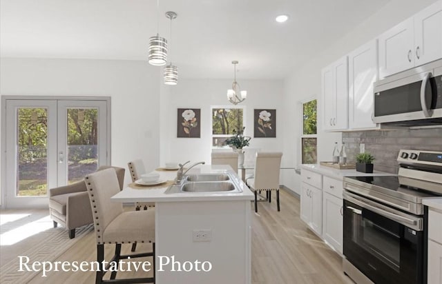 kitchen featuring white cabinets, a breakfast bar, sink, and stainless steel appliances