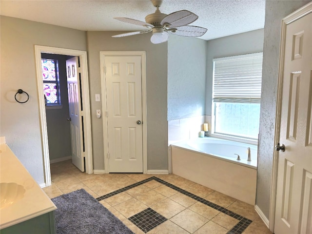 bathroom featuring vanity, a tub, tile patterned floors, and a textured ceiling