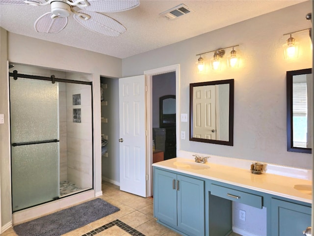 bathroom featuring ceiling fan, tile patterned flooring, a textured ceiling, vanity, and a shower with shower door