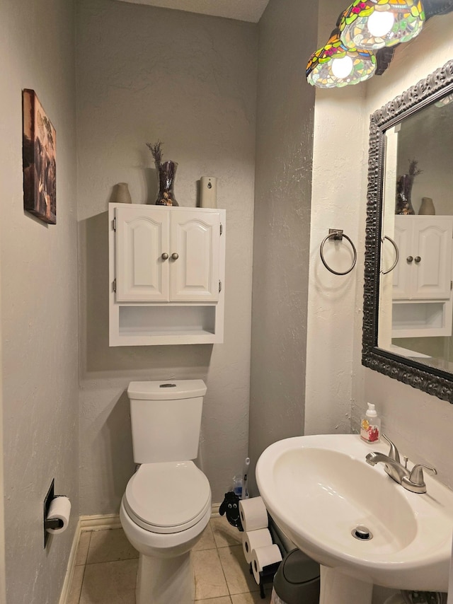 bathroom with tile patterned flooring, sink, and toilet