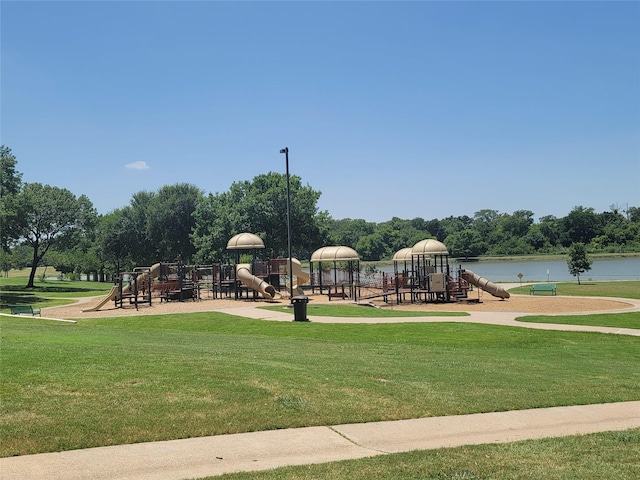 view of playground featuring a lawn and a water view