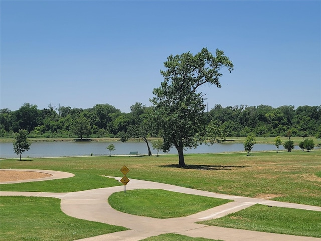 view of property's community with a water view and a lawn