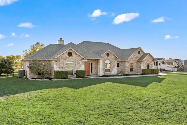 view of front of house with central AC and a front lawn